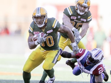 John White of the Edmonton Eskimos breaks a tackle by Montreal Alouettes' Jovon Johnson during CFL action at Molson Stadium in Montreal on Monday, Oct. 10, 2016.