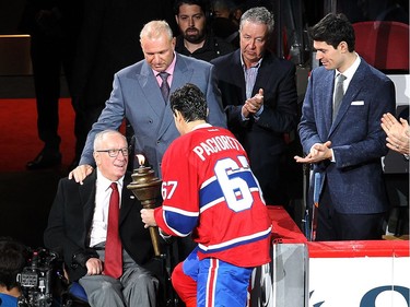 Montreal Canadiens's Max Pacioretty gets torch from Jacques Demers, while Michel Therrien and Carey Price, far right, look on, prior to first period NHL action in Montreal on Tuesday October 18, 2016.