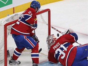 Montreal Canadiens goalie Carey Price looks for puck bouncing above his shoulder has defenceman Mikhail Sergachev (22) covers the crease, during second period NHL action in Montreal on Thursday October 20, 2016.