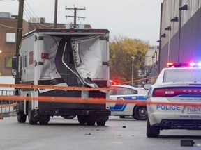 A police car sits behind a Garda truck that had its back end smashed in by thieves who used a large front end loader to break into the truck and steal its contents in Pointe Claire a suburb west of Montreal, on Friday October 21, 2016.