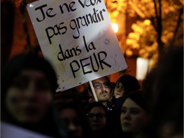 A man holds his daughter and a sign that reads "I do not want to grow up in fear" during a protest to denounce rape culture in Place Émilie-Gamelin on Wednesday, Oct. 26, 2016.