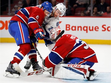 Montreal Canadiens defenceman Shea Weber leans on Tampa Bay Lightning left wing Jonathan Drouin as Montreal Canadiens goalie Carey Price covers the puck during NHL action at the Bell Centre in Montreal on Thursday October 27, 2016.