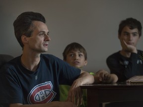 Alex Reede with his two sons at their Vaudreuil-Dorion home: "Sometimes, my wife is working a 4 to 12 night shift," he said. "I have to leave for work at 4:20 in the morning — she won't be able to sleep if she's bringing me to work. Someone's going to burn out."