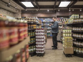 Employee Roberto Santinelli verifies prices two days before the Oct. 5 reopening of Milano grocery store on St-Laurent Blvd.