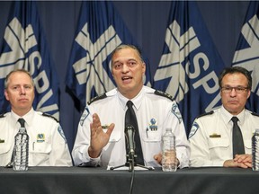 Montreal Police chief Philippe Pichet, flanked by deputy directors Claude Bussiere, left, and Bernard Lamothe, speaks to reporters about the force's surveillance of La Presse reporter Patrick Lagacé.