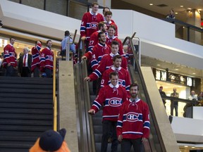 The Montreal Canadiens' NHL team descends the escalator as the  2016-17 edition is introduced to the public at Complexe Desjardins in Montreal, Oct. 5, 2016.