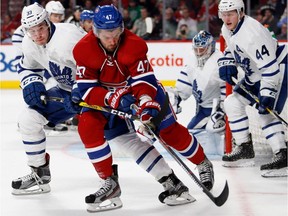 Montreal Canadiens right wing Alexander Radulov beats Toronto Maple Leafs centre Frederik Gauthier to the puck during preseason NHL action at the Bell centre in Montreal on Thursday October 6, 2016.  Toronto Maple Leafs defenseman Morgan Rielly, right, looks on.