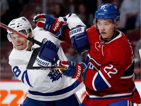 Toronto Maple Leafs left wing Milan Michalek, left, grimaces as he is cleared from the goal crease by Montreal Canadiens defenceman Mikhail Sergachev as Montreal Canadiens goalie Carey Price looks on during pre-season NHL action at the Bell centre in Montreal on Thursday October 6, 2016.