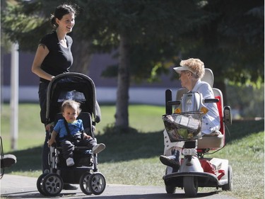 Corinne Stocker (right) stops to talk with Amanda (no last name given) and her children Max and Chase (obscured) in Benny Park in Montreal on Friday, October 7, 2016.