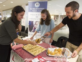 Myriam Deeb, left, gets some food at the Syrian Kids Foundation's weekly Concordia bake sale last Friday with the help of Salma Zin Alabdin and Brandon Paytiss.