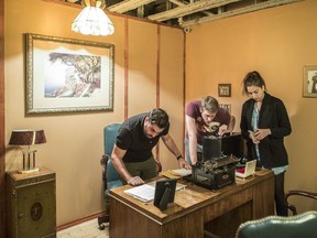 Friends Charles Blanc (left to right), Alexis Dupire and Clemence Bergier look for clues in a 1930's mafia-themed escape room at Question Games in Montreal on Sunday, October 9, 2016.