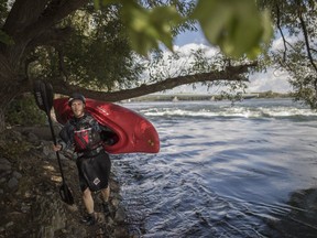 Sylvain Pelletier walks along the shore of the St. Lawrence River as he enjoys one of his vacation days to kayak on a warm early fall day in Montreal on Tuesday, Sept. 27, 2016. Earlier this year, a U.S. environmental group placed the St. Lawrence on its annual list of the most endangered rivers.