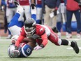 Alouettes slotback Nik Lewis, left, is tackled by Calgary Stampeders defensive back Brandon Smith during first half CFL football action Sunday, Oct. 30, 2016, in Montreal.