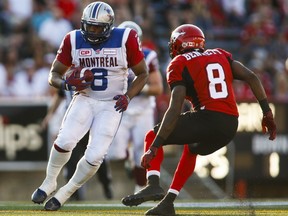 Montreal Alouettes' Nik Lewis, left, tries to get past Calgary Stampeders' Fred Bennett during second half CFL football action in Calgary on Saturday, Aug. 1, 2015.