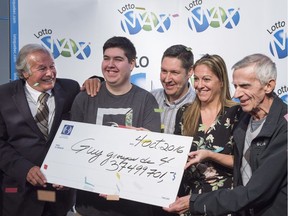 Patrick Lamothe and wife Johanne Leblond, their son Yanick and Johanne's father Guy Leblond, right, are presented with their cheque for the $37.5-million jackpot win in the Sept. 30 Lotto Max draw by Guy Corbeil Tuesday, Oct. 4, 2016 in Montreal.