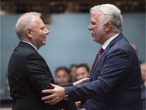 Quebec Premier Philippe Couillard, right, and Parti Québécois Opposition Leader Jean-François Lisée shake hands before question period Tuesday, Oct. 18, 2016 at the legislature in Quebec City. Lisée was elected leader of the PQ on Oct. 7.