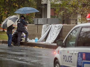 Police examine and photographic evidence at the scene of an overnight stabbing that has left a 15-year-old boy dead on Nuns' Island in Montreal, on Saturday October 29, 2016.
