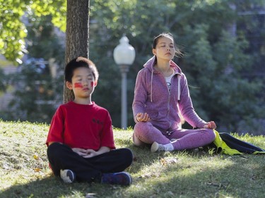 Qing Li and her son Ethan meditate in Westmount Park on Friday, October 7, 2016.