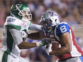 Saskatchewan Roughriders' Shane Herbert, left, tackles Montreal Alouettes' Nik Lewis during second half CFL football action in Montreal on July 29, 2016.