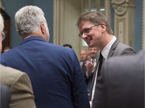 Quebec Opposition and Parti Québécois interim leader Sylvain Gaudreault, right, is congratulated by Quebec Premier Philippe Couillard as members of the legislature, as they acknowledge his last question period as party leader at the legislature in Quebec City, Wednesday, October 5, 2016. Gaudreault will step down as the PQ elects a new leader on Friday.