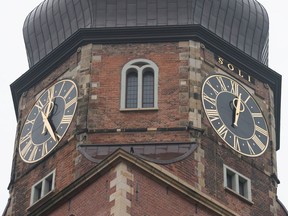The clocks at St. Katharinen church in Hamburg, Germany, Oct. 16, 2016. A 20-kilogram minute hand fell off the clock, right, on the Hamburg church tower.