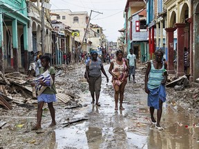 Picture taken by the UN Mission in Haiti (MINUSTAH) in the town of Jeremie, Haiti on Thursday October 6, 2016 showing people walking down a flooded street. The city lies on the western tip of Haiti and suffered the full force of the category 4 storm, leaving tens of thousands stranded.   Hurricane Matthew passed over Haiti on Tuesday October 4, 2016, with heavy rains and winds. While the capital Port au Prince was mostly spared from the full strength of the class 4 hurricane, the western cities of Les Cayes and Jeremie received the full force sustaining wind and water damage across wide areas. /