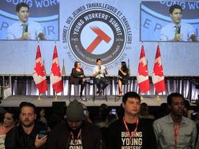 Protesters turn their backs on Prime Minister Justin Trudeau as he addresses the Canadian Labour Congress National Young Workers' Summit in Ottawa on Tuesday October 25, 2016. Among their concerns: the Trans Pacific Partnership and ongoing problems with the federal Phoenix payroll system, but also high student debt and the lack of good jobs.