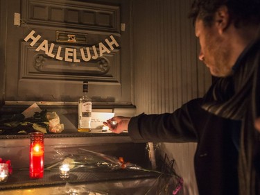 A man lights a candle in front of the home of legendary singer and poet Leonard Cohen Thursday, November 10, 2016 in Montreal. Cohen has died at the age of 82.