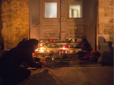 A man places candles in front of the home of legendary singer and poet Leonard Cohen Thursday, November 10, 2016 in Montreal. Cohen has died at the age of 82.