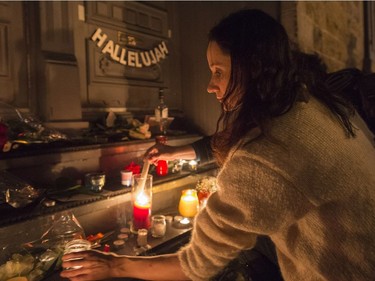 A woman places a candle in front of the home of legendary singer and poet Leonard Cohen Thursday, November 10, 2016 in Montreal. Cohen has died at the age of 82.