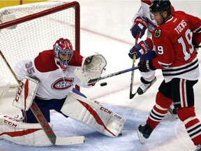 Montreal Canadiens goalie Al Montoya, left, blocks a shot by Chicago Blackhawks center Jonathan Toews during the first period of an NHL hockey game in Chicago, Sunday, Nov. 13, 2016.