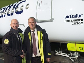 Bombardier CEO Alain Bellemare, left, and Air Baltic CEO Martin Gauss shake hands during a ceremony to mark the first delivery of Bombardier's CS300 to Air Baltic in 2016.
