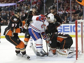 Anaheim Ducks goalie John Gibson, right, stops a shot in front of Montreal Canadiens' Phillip Danault, center, during the first period of an NHL hockey game Tuesday, Nov. 29, 2016, in Anaheim, Calif.