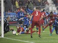 Toronto FC's Armando Cooper (right) scores his team's first goal on Montreal Impact goalkeeper Evan Bush during first half Eastern Conference final MLS action in Toronto on Wednesday November 30, 2016.