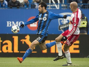 Montreal Impact's Matteo Mancosu, left, scores against the New York Red Bulls as Red Bulls' Aurelien Collin defends during second half action of the first leg of the eastern conference MLS soccer semifinal in Montreal, Sunday, October 30, 2016.