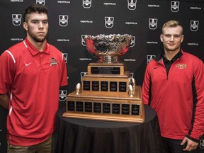 Calgary Dinos quarterback Jimmy Underdahl, right, and Laval Rouge Et Or quarterback Hugo Richard stand next to the Vanier Cup during a media conference in Hamilton, Ont., on Nov. 24, 2016. Fifth-year quarterback Jimmy Underdahl will have his university football career come to an end Saturday at the Vanier Cup. He still doesn't know if he'll be a starter or a backup for his final game. Calgary head coach Wayne Harris said Friday that he has yet to decide whether Underdahl or rookie Adam Sinagra will get the start when the Dinos face the Laval Rouge et Or at Tim Hortons Field.