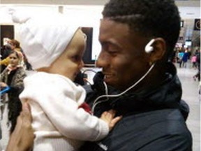 Darius Brown holds a young relative at Trudeau airport.