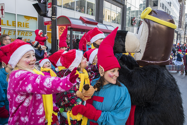 Leanea Marsolais, left, and Genevieve Tremblay watch the annual Santa Claus Parade on Ste-Catherine street in downtown Montreal on Saturday, November 19, 2016.