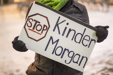 A demonstrator holds a sign during a vigil against the British Columbia Kinder Morgan pipeline expansion in Montreal on Monday, November 21, 2016. The $6.8-billion Kinder Morgan's Trans Mountain pipeline expansion project would ship oil from Alberta’s oil sands to British Columbia through Vancouver’s harbour.