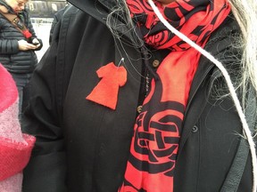 Demonstrator wears a felt red dress pin as part of a public demonstration by aboriginal women outside the National Assembly in Quebec to call for an inquiry into police abuse. Caroline Plante/Montreal Gazette
