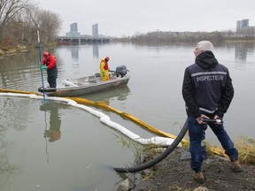 On Day 2 of Montreal's sewage dump into the St. Lawrence in 2015, a crew cleans debris from water at the exit to a channel leading from the St Pierre sewage discharge point in Verdun.
