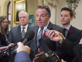 Coalition Avenir Québec Leader François Legault responds to reporters before entering a caucus meeting at the provincial legislature, in Quebec City on Wednesday, November 2, 2016. Legault is flanked by CAQ MNAs François Paradis, left, and Simon Jolin-Barrette.