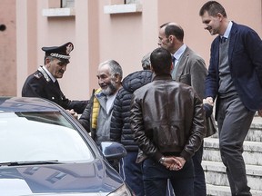 Danilo Calonego, second from left, leaves a police station after being questioned by prosecutor Sergio Colaiocco, in Rome, Saturday, Nov. 5, 2016, after being freed. Calonego and two colleagues had been kidnapped at Gath, Libya, on Sept. 19.