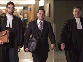 Ex-Montreal mayor Michael Applebaum, flanked by his lawyers, arrives at the Montreal courthouse, Nov. 14, 2016, during his fraud trial.