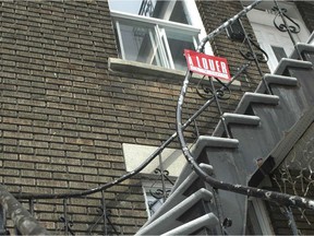 A For Rent sign on a winding outdoor staircase in Montreal.