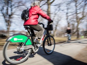 A woman rides a Bixi through the bicycle path in Lafontaine Park in the Plateau-Mont-Royal in Montreal on Monday, April 15, 2013.