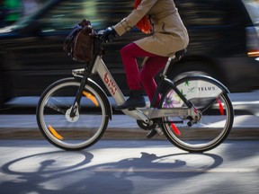 Cyclist rides a Bixi bicycle on the bike path on de Maisonneuve Blvd., near the corner of Stanley St. in downtown Montreal