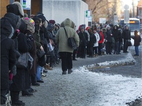 Commuters brave the cold as they wait for the 211 Bord-du-Lac bus, on Monday February 16, 2015 at the Lionel-Groulx métro station.