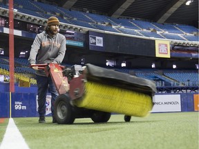 Simon Larouche levels the filling for the artificial turf at Montreal Olympic stadium on Thursday March 31, 2016. Montreal is hosting pre-season games of Major League Baseball on Friday and Saturday. The Toronto Blue Jays will meet the Boston Red Sox. (Pierre Obendrauf / MONTREAL GAZETTE)