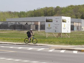 A cyclist rides past an unfinished arena in Pincourt, Thursday, May 15, 2014.  (Phil Carpenter / THE GAZETTE)